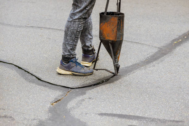 istock Restoration work sealing cracks applying liquid sealer to asphalt a road protective coat on roadway 1283908855