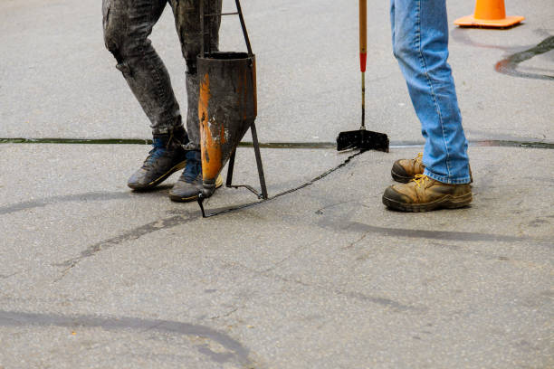istock Restoration work applying liquid sealer to asphalt a road protective coat 1283908860