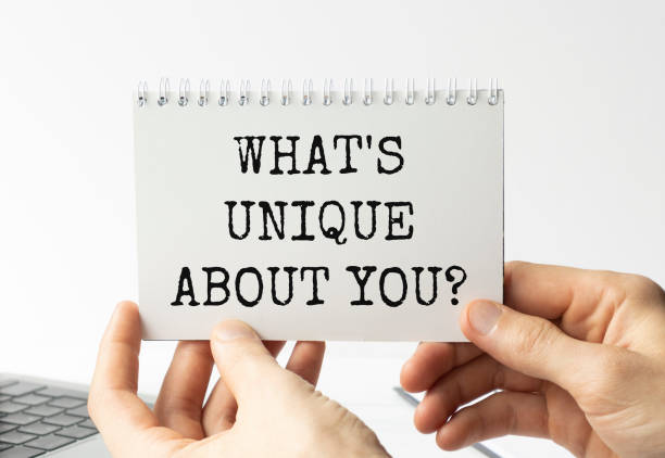 istock Businessman hands hold card with What is unique about you question 1283910934
