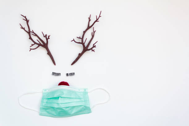 istock Christmas reindeer concept with protective face mask. White background with copy space. Concept of Christmas during covid-19 pandemic 1283912524
