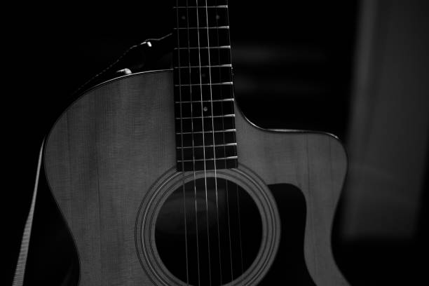 istock A professional acoustic guitar stands on stage on a black background. Black and white photography 1283912719