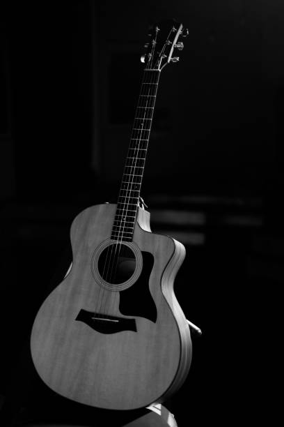 istock A professional acoustic guitar stands on stage on a black background. Black and white photography 1283912799
