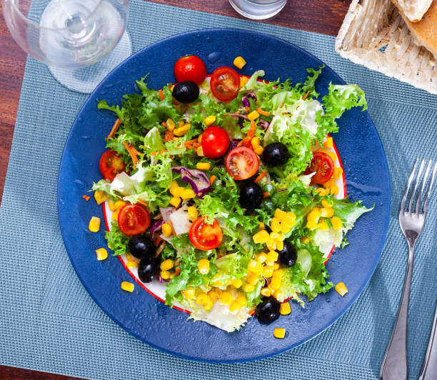 istock Fresh mixed salad with lettuce, corn, olives and cherry tomatoes 1283912953