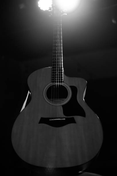 istock A professional acoustic guitar stands on stage on a black background. Black and white photography 1283913077