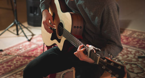 istock Young man playing on acoustic guitar 1283913690