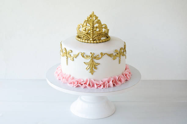 istock Cake decorated with golden crown on a white background for a princess 1283914286