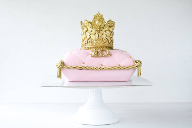 istock Cake pillow decorated with golden crown on a white background for a princess 1283914302