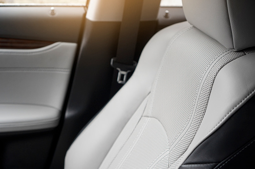 Premium car interior detail. White leather ventilated seats of modern car.
