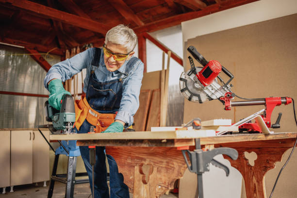 istock Mature female carpenter working with nail gun. 1283918359