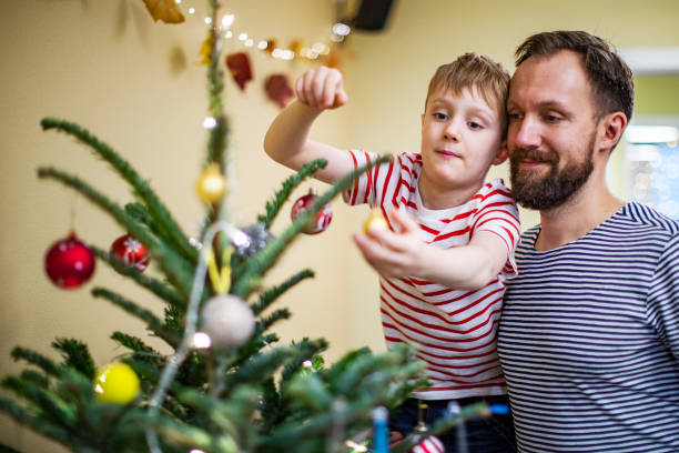 istock Father and son decorating the Christmas tree 1283919185