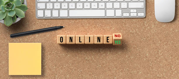 istock cubes with message ONLINE YES / NO and office equipment 1283919220