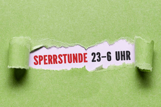 istock torn paper revealing the German message CURFEW 11pm to 6am 1283919226