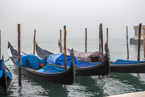 Gondola in a thick fog during nightfall in Venice, panoramic shot, Grand Canal