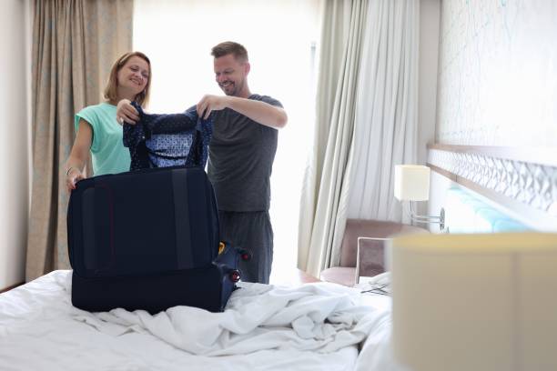 istock Young man and woman are putting things in suitcase 1283919671
