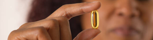 mulher africana mostrando pílula - gel effect capsule pill vitamin e - fotografias e filmes do acervo