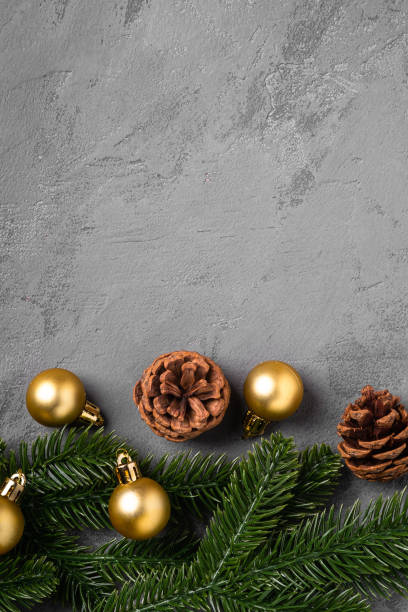 istock Christmas composition. Golden baubles, pine cones and fir needles decorations on grey background. Top view copy space 1283920587