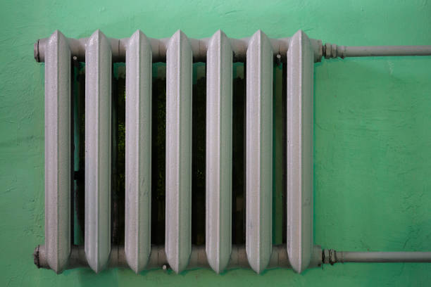 istock gray painted cast iron water radiator on green wall 1283921690