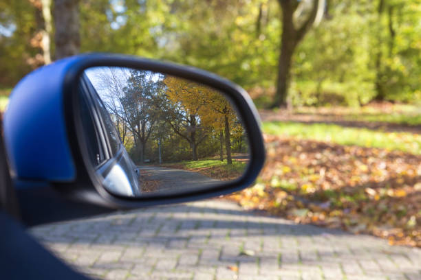 espejo del coche des cerdo con hermoso paisaje otoñal en la reflexión, en la carretera con el coche en la carretera vacía fondo borroso - rear view mirror car mirror sun fotografías e imágenes de stock