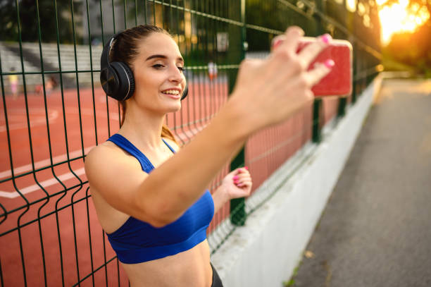 Woman taking a selfie with mobile phone while resting after exercise