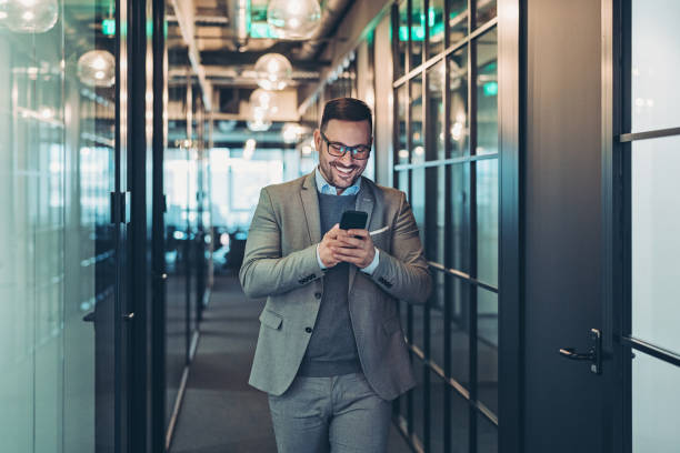 istock Businessman texting while walking in the corridor 1283924447