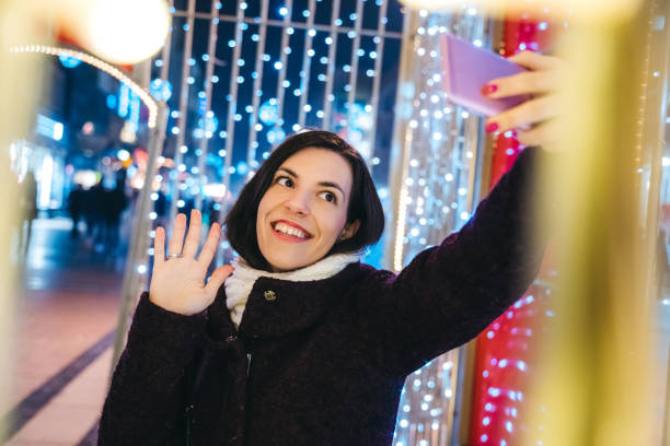 istock Woman making selfie among Christmas string lights 1283925513
