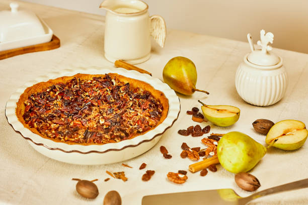 istock Home made pear tart with fresh pears and pecans on light linen tablecloth. Healthy eating sweet organic food concept. Selective focus. Top view. 1283926489
