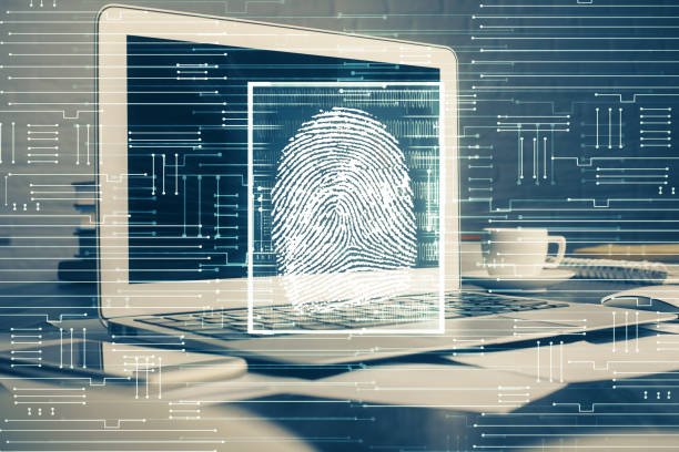 istock Computer on desktop in office with finger print drawing. Double exposure. Concept of business data security. 1283930372