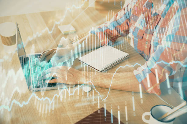 istock Multi exposure of forex graph with man working on computer on background. Concept of market analysis. 1283931488