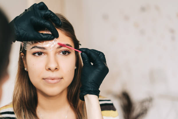 istock Eyebrow shaping procedure, make-up master uses brush to shape the eyebrows. 1283931880