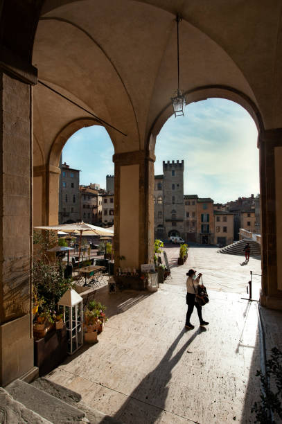 la gente cammina attraverso la loggia vasariana in piazza grande, arezzo, italia. - arezzo foto e immagini stock