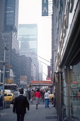 New York City, NY, USA, 1980. Street scene with pedestrians, shops, high-rise buildings and traffic in Manhattan, New York City.