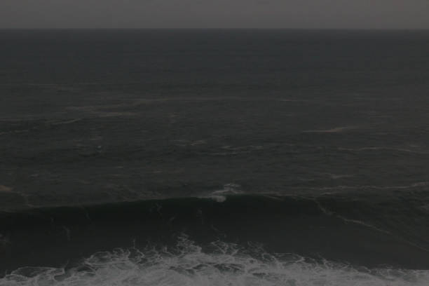istock Full frame grey background from ocean water with big waves in monochrome gray 1283934596