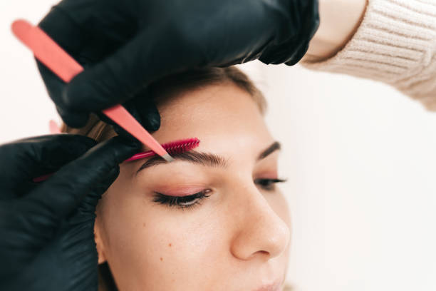 istock Make-up master uses tweezers and brush to shape the eyebrows. 1283937146