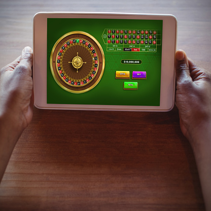 Online Roulette Game  against cropped hands of woman using digital tablet