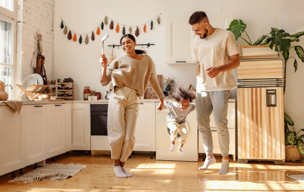 energiczna wielorasowa rodzina bawiąc się i tańcząc w kuchni - domestic kitchen people fun lifestyles zdjęcia i obrazy z banku zdjęć