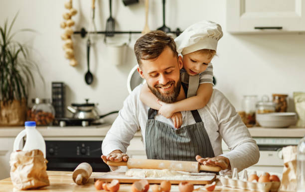 istock Cheerful man with little son making pastry at home 1283939351