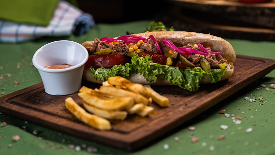 Tuna fish sandwich and french fries on cutting board