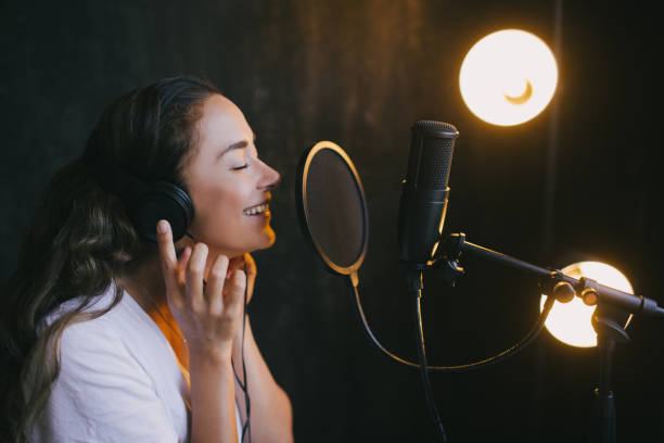 istock Young beautiful woman singing in microphone, recording voice in a studio. 1283940695