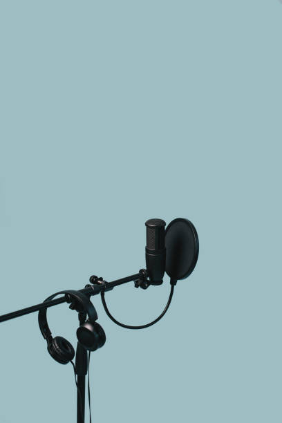 istock Items for podcasting: professional microphone and earphones isolated on blue background. Place for text. 1283940706