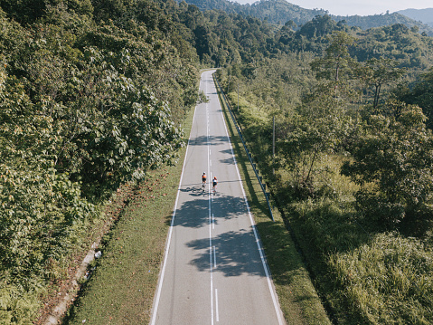 Bike ride road trip at rural area ulu langat with 2 sportswoman athlete rider in the morning drone view