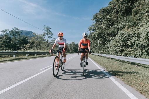 2 asian chinese woman road cyclist cycling in rural area in the morning