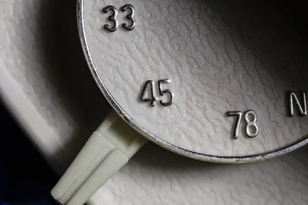 Macro close up photograph of 33, 45 or 78 rpm selector switch on vintage record player turntable.