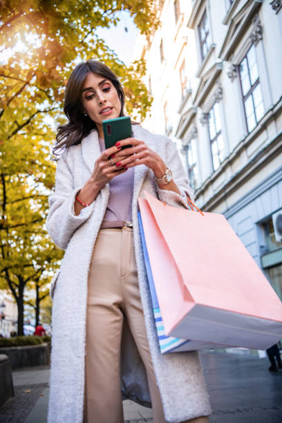 istock Mid Adult woman texting while enjoying a day shopping 1283949780