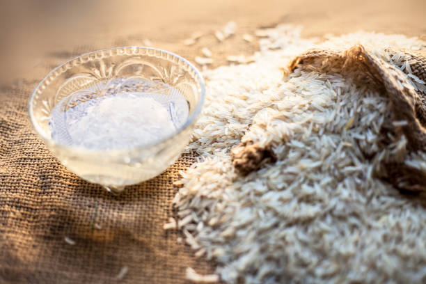 바스마티 흰 쌀로 가득 찬 건니 백이 있는 유리 그릇에 쌀물을 갈색 표면 위에 얹습니다. - rice cereal plant white rice white 뉴스 사진 이미지