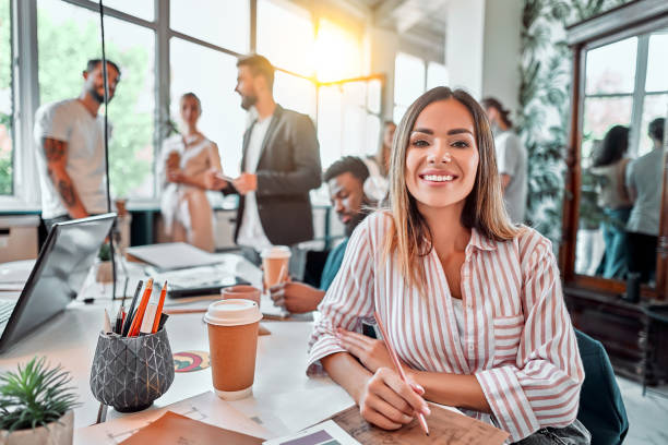 istock Smiling female employee sit in coworking space and working on the project 1283955441