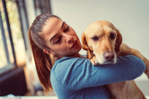 istock Young woman embracing small brown dog 1283956800