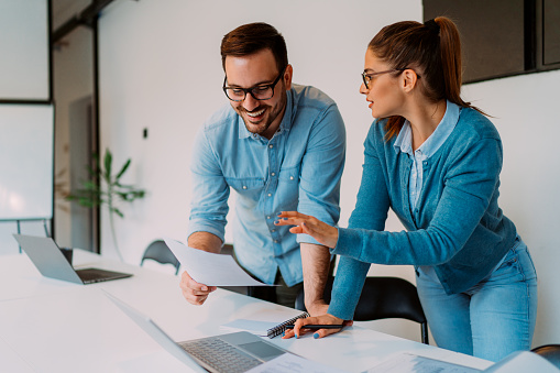 Business colleagues standing by the desk and working together in the office