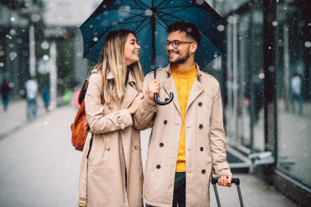 istock beautiful smiling young couple walking in the rain 1283962686