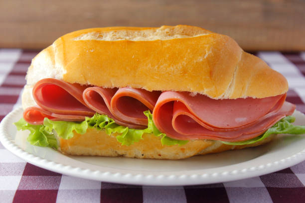 mortadella sandwich on rustic wooden table for breakfast. Italian food. mortadella sandwich on rustic wooden table for breakfast. Italian food. Selective focus baloney stock pictures, royalty-free photos & images