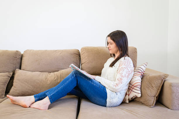 istock Young girl studying sitting on sofa 1283977727